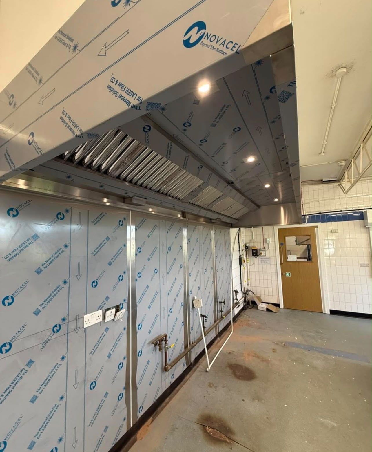 Stainless steel canopy and clad walls with protective film still in place, ready for cooking equipment